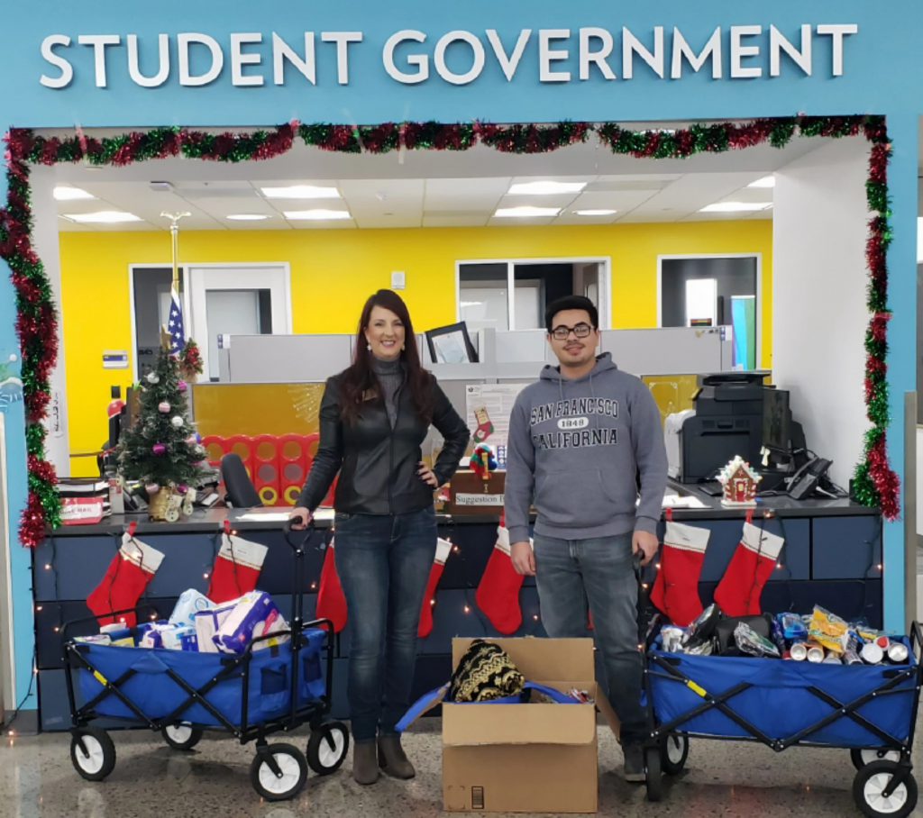 epartment of Communication Professor Charlene S. Gibson and one of her students, Brian Arreola, stand with their #TeamGibsonGives Coyote Cupboard donation, part of a group advocacy project in their COM 115 Applied Communication classes.